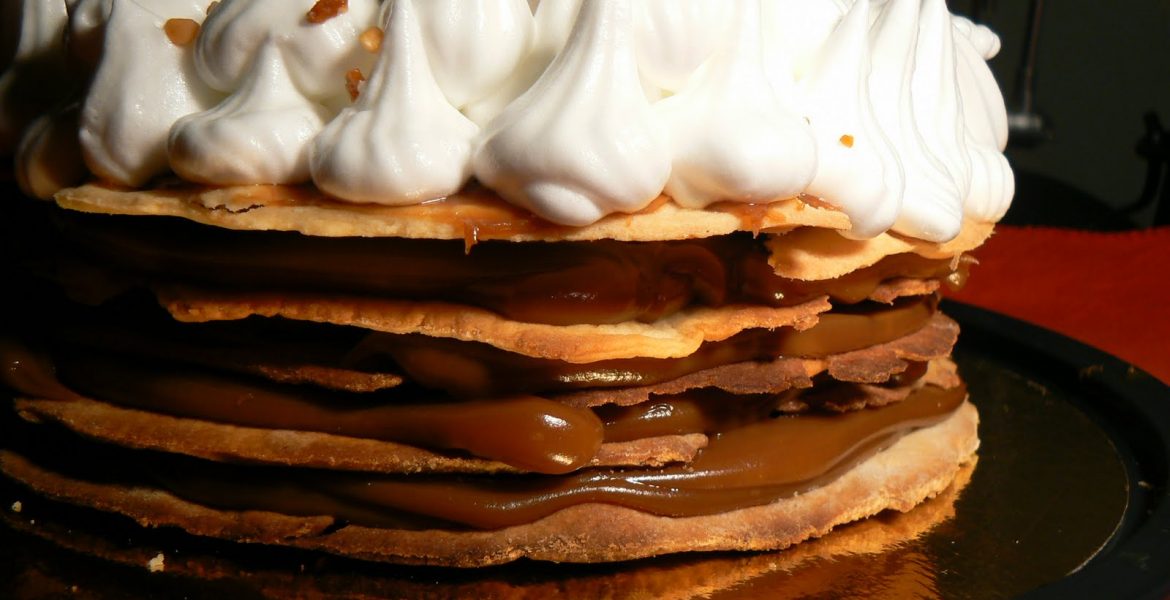 foto de torta rogel de 5 tapas con dulce de leche y copos de merengue y trocitos de almendras