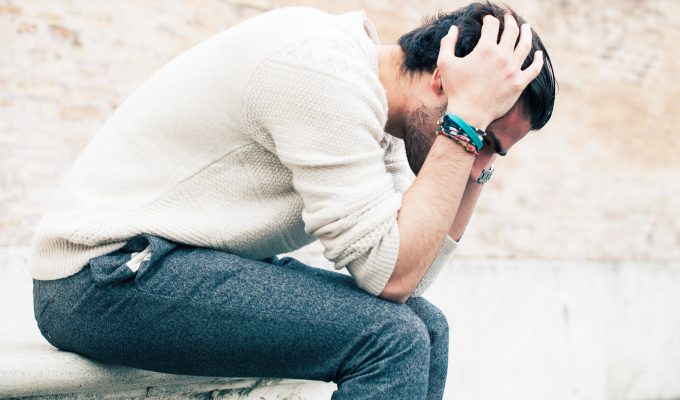 Hombre joven estresado y preocupado, con crisis de ansiedad