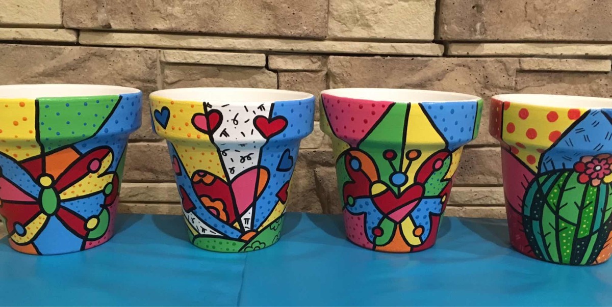Ideas para pintar macetas estilo Pop Art. Colección de macetas de barro pintadas a mano con vibrantes diseños de estilo pop art con mariposas y corazones.