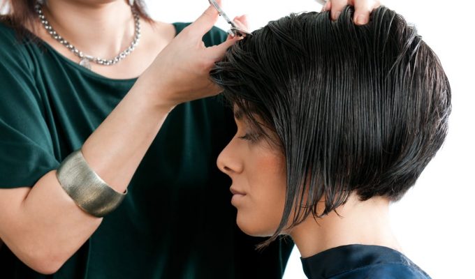 Mujer cortándose el cabello corto para estar a la moda
