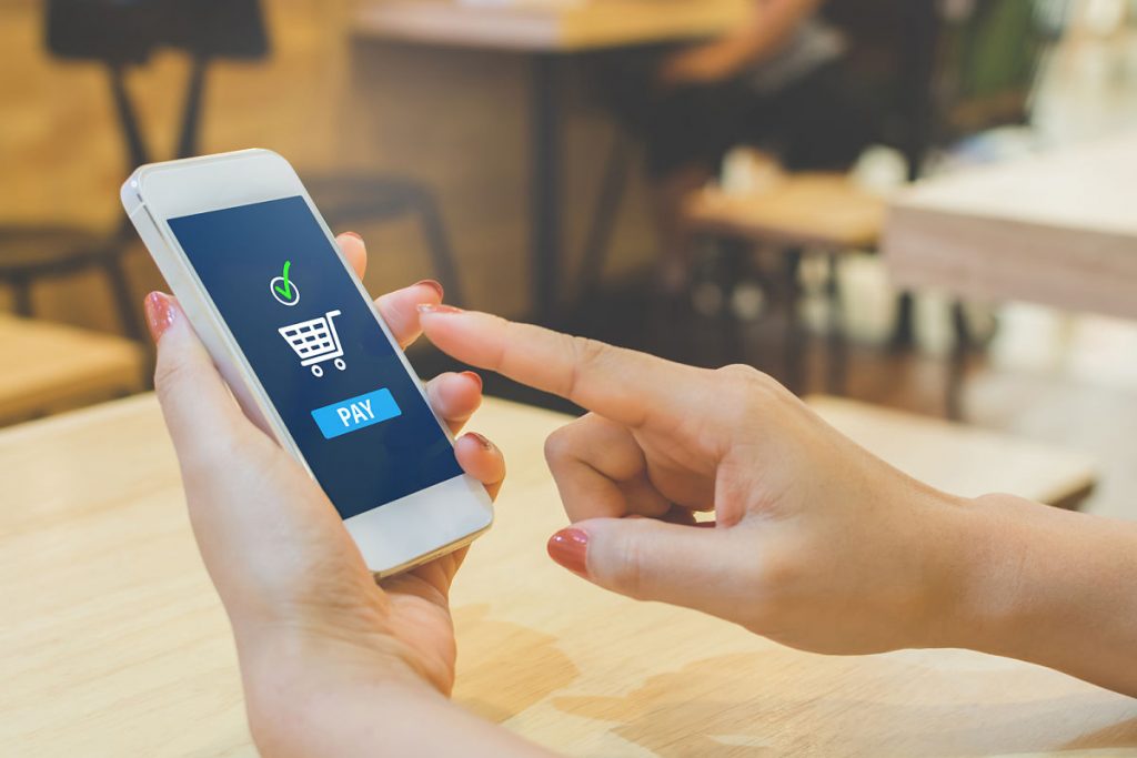 Realizar Pagos Online de Forma Segura Punto de realizar un pago online desde su celular, completando una compra en una tienda de e-commerce de forma fácil y rápida.