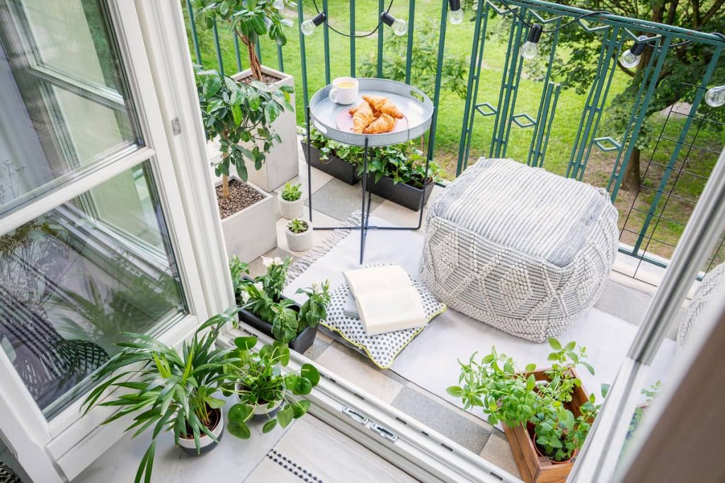 Tu Oasis Personal en el Balcón Acogedor balcón lleno de plantas saludables y con buena ventilación, un ejemplo de cómo crear un oasis urbano y evitar enfermedades en las plantas.