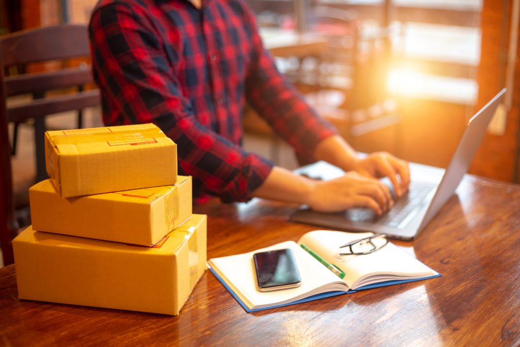 Estrategia para Comprar en Amazon Aprovechar las ofertas del Amazon Prime Day, con paquetes apilados en su escritorio.