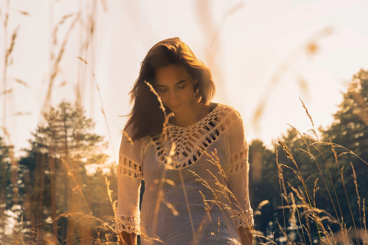 Mujer conectando con el cosmos para recibir las predicciones del horóscopo de agosto durante la temporada de Leo.