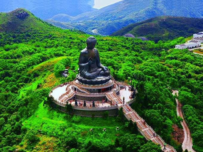 Vista aérea del Gran Buda de Tian Tan, una monumental estatua de Buda ubicada sobre una colina rodeada de vegetación en la isla de Lantau, Hong Kong.