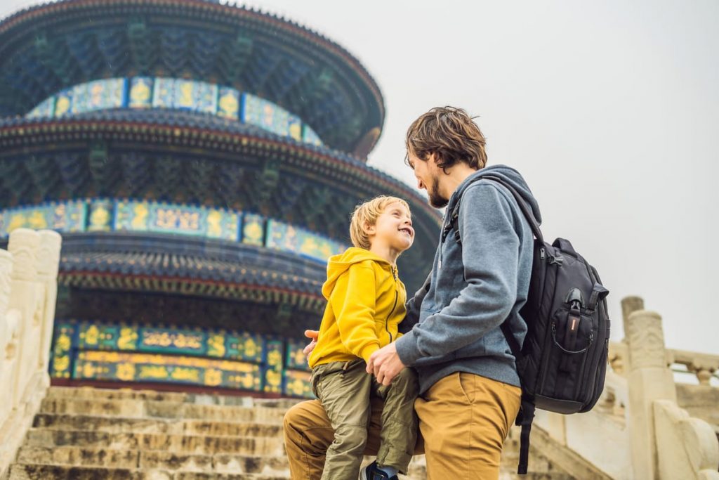 Padre e hijo compartiendo un momento feliz mientras viajan y visitan un templo, una idea de regalo de viaje inolvidable para el Día del Padre.
